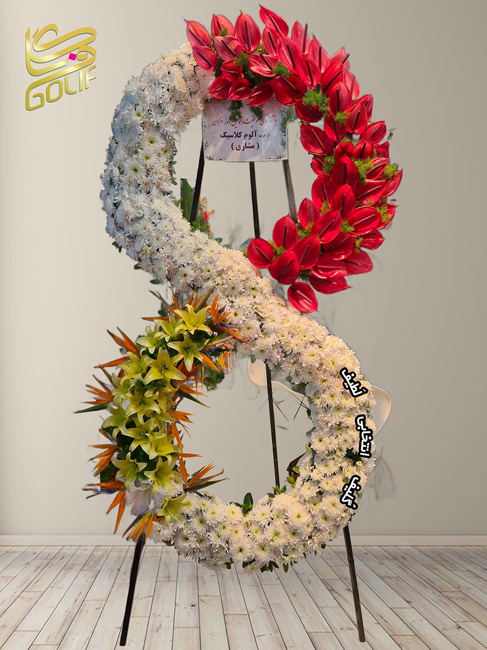 تاج گل تبریک دو طبقه تاج گل به شکل عدد ۸ طراحی شده است و گل‌های اصلی و غالب آن شامل موارد زیر هستند: گل داوودی سفید: گل غالبی که شکل اصلی عدد ۸ را تشکیل داده است. آنتوریوم قرمز: در بخش بالا و سمت راست تصویر برجسته است. گلای لیلیوم زرد: در قسمت پایین و سمت چپ تصویر حضور دارد. گل پرنده بهشتی نارنجی: در بخش پایین ترکیب اضافه شده است که جذابیت خاصی به طراحی می‌دهد تاج گل افتتاحیه، تاج گل نمایشگاهی، تاج گل عقد و عروسی سفارش آنلاین تاج گل