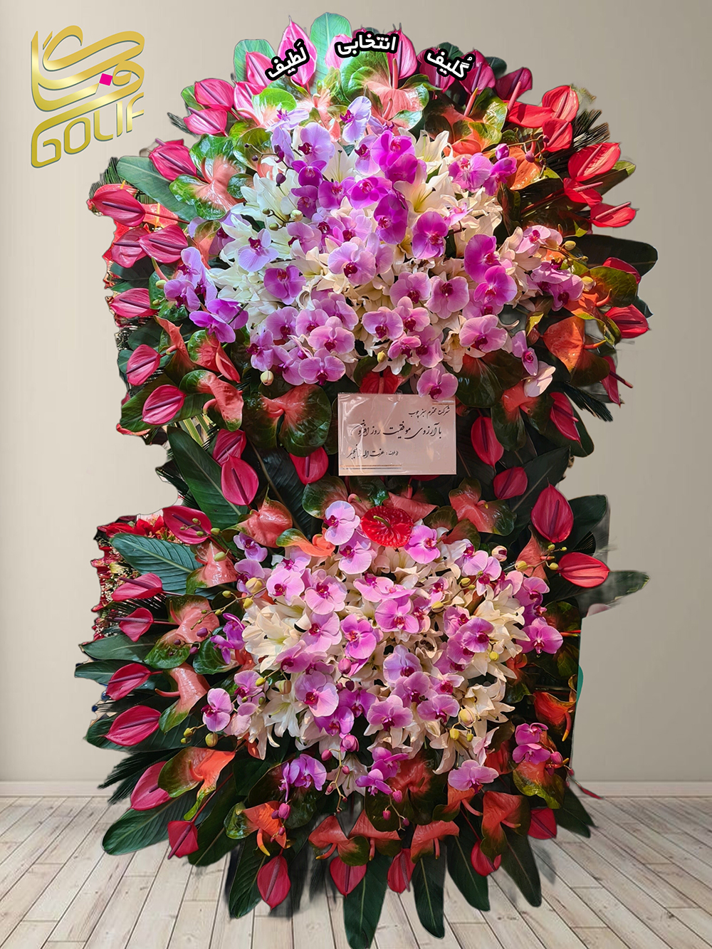 تاج گل تبریک دو طبقه (آنتوریوم، ارکیده‌) گل‌های اصلی و غالب این تاج گل شامل موارد زیر هستند: آنتوریوم قرمز: در قسمت‌های مختلف تاج گل به‌خصوص در اطراف بخش مرکزی جلوه زیبایی دارد. ارکیده‌های صورتی، سفید و بنفش: این گل‌ها در مرکزیت ترکیب و حلقه‌های گل‌آرایی به‌وضوح دیده می‌شوند. این دو نوع گل از لحاظ رنگ و سبک طراحی، بیشتر به چشم می‌آیند و نمایانگر شکوه و زیبایی این تاج گل هستند. تاج گل افتتاحیه، تاج گل نمایشگاهی، تاج گل عقد و عروسی سفارش آنلاین تاج گل سفارش آنلاین گل